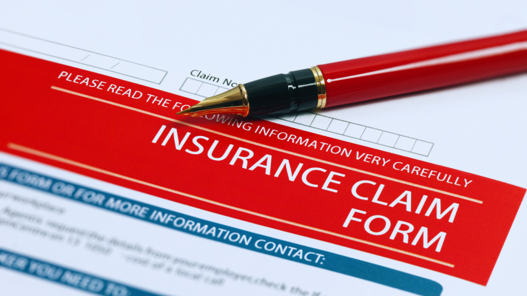 Roof insurance claim form with a red pen, representing the process of filing a roof damage insurance claim for storm-related repairs.