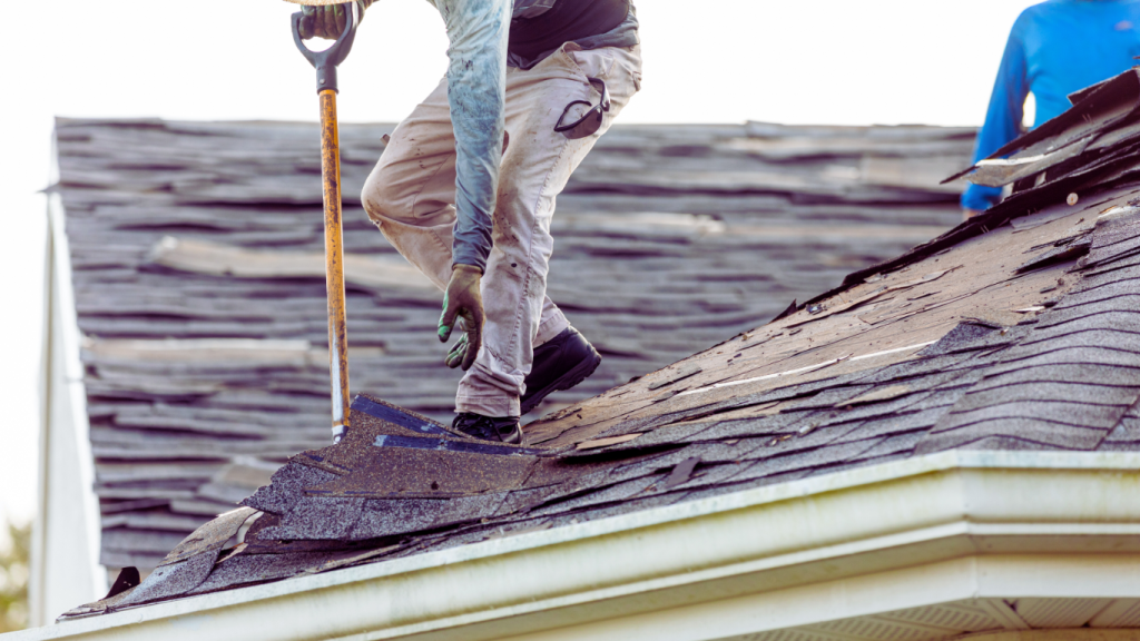 Roofing professionals removing damaged shingles to restore a storm-affected home, providing fast and reliable emergency roof repair services.